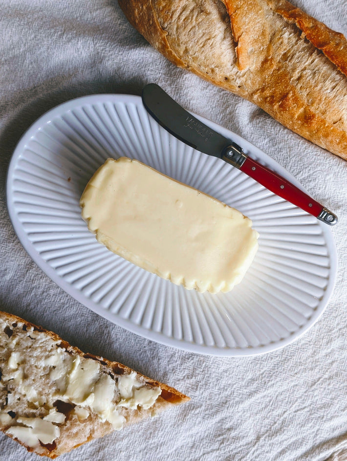 Slow-Churned French Butter on a plate with a knife and bread