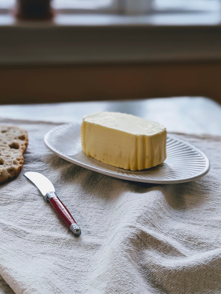 Slow-Churned French Butter on a plate with a knife and bread