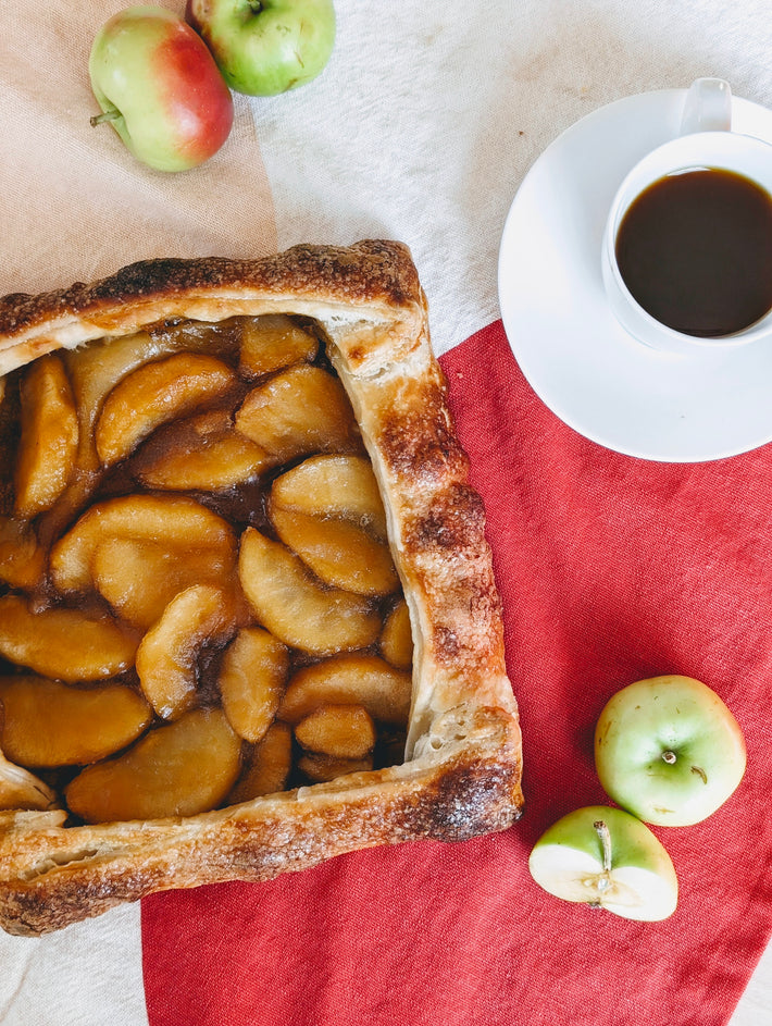 Apple Caramel Galette with coffee and apples on a table