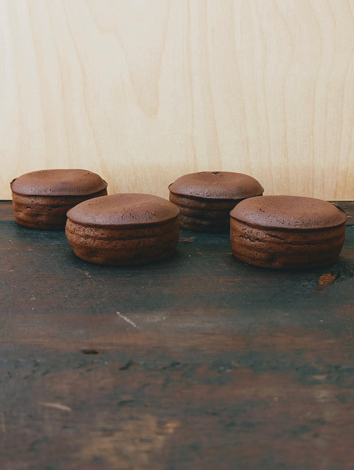 Four chocolate lava cakes on a wooden surface