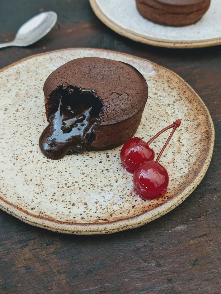 Chocolate Lava Cake with a gooey chocolate center and cherries on a plate