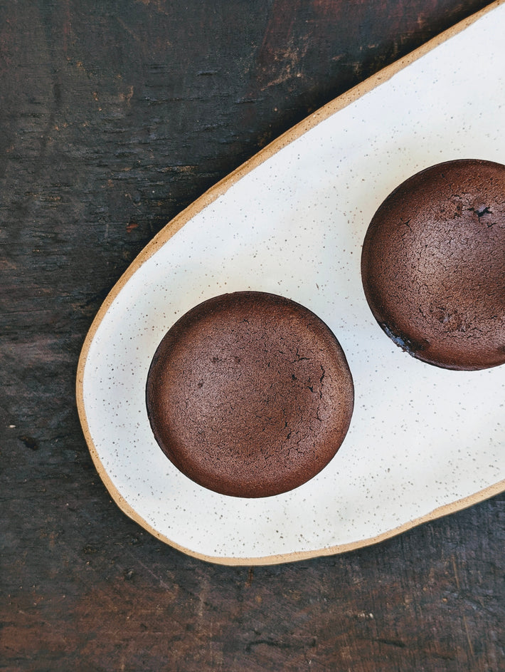 Two chocolate lava cakes on a speckled white plate