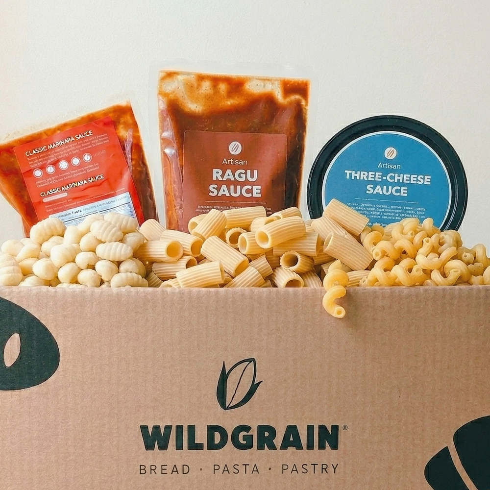 Box of Wildgrain with pasta and sauce packets on a wooden surface