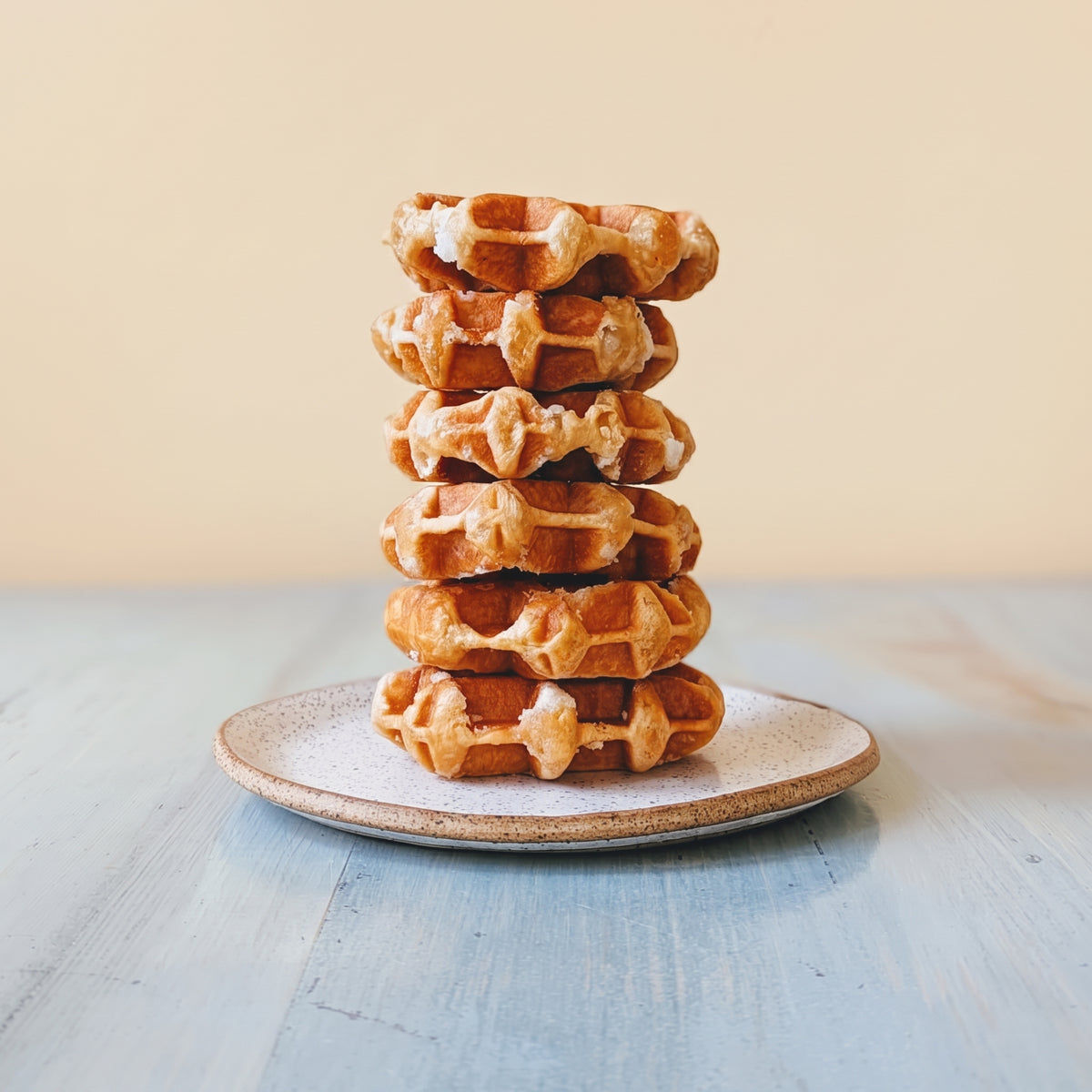 Front view of Pumpkin Spice Belgian Waffle showcasing a stack of golden waffles on a plate with a light blue wooden background