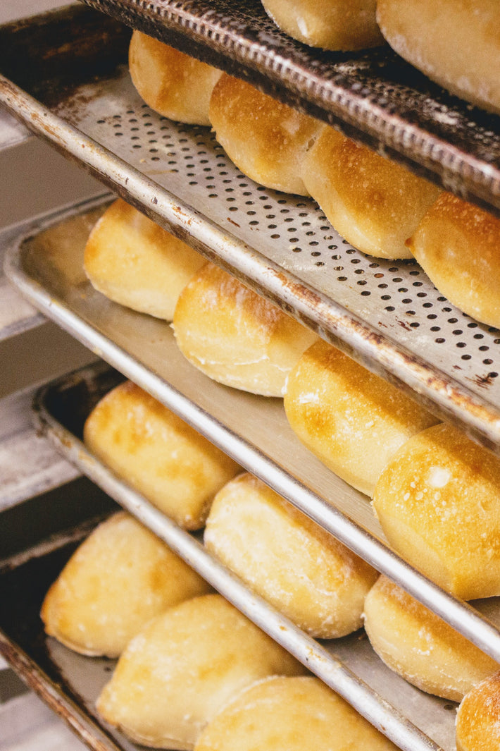 Freshly baked ciabatta rolls on a tray