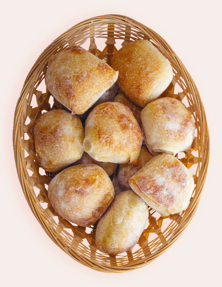 A basket of crusty sourdough rolls