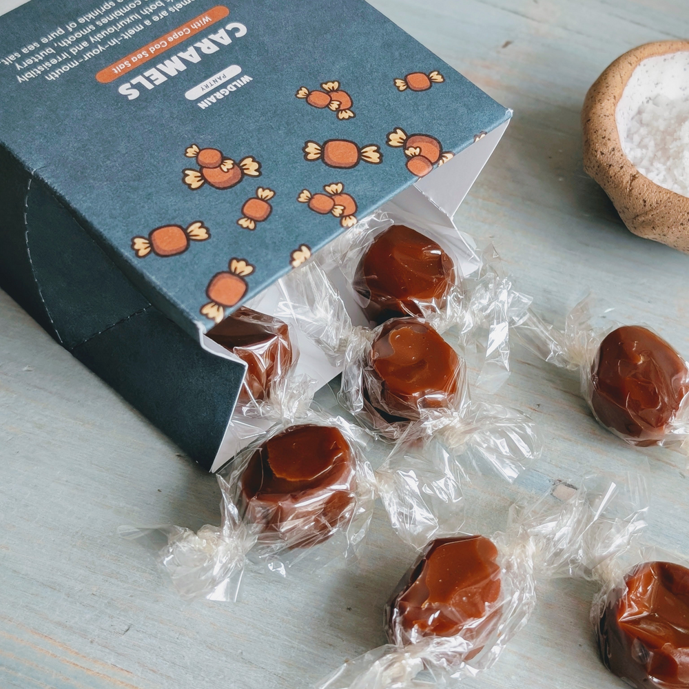 Wrapped sea-salt caramels spilling from a blue box labeled CARAMELS