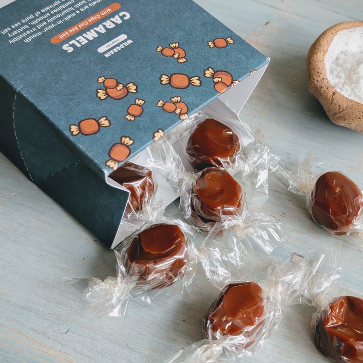 Wrapped sea-salt caramels spilling from a blue box labeled CARAMELS
