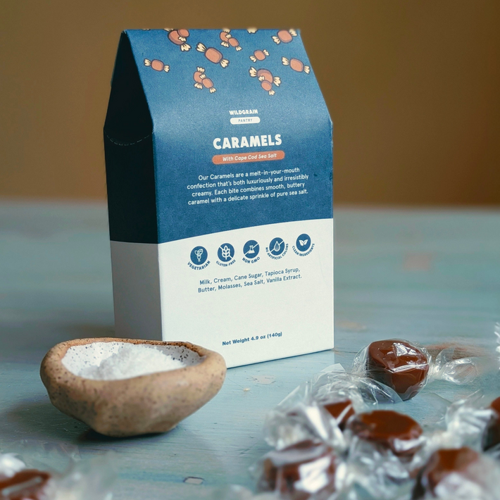 Blue-and-white Wildgrain Pantry box labeled CARAMELS — "With Cape Cod Sea Salt", small bowl of salt and wrapped caramels.