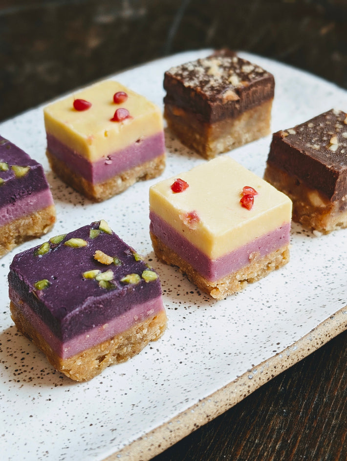 Layered desserts with various colors and toppings on a plate