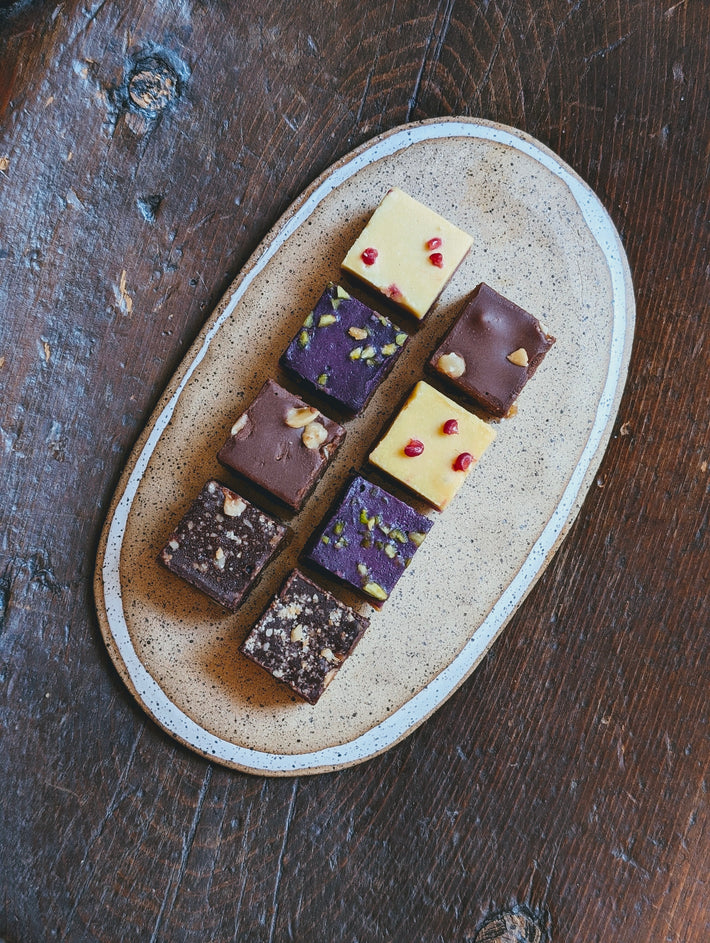 Assorted mini layer cakes on a plate, featuring various flavors and toppings.