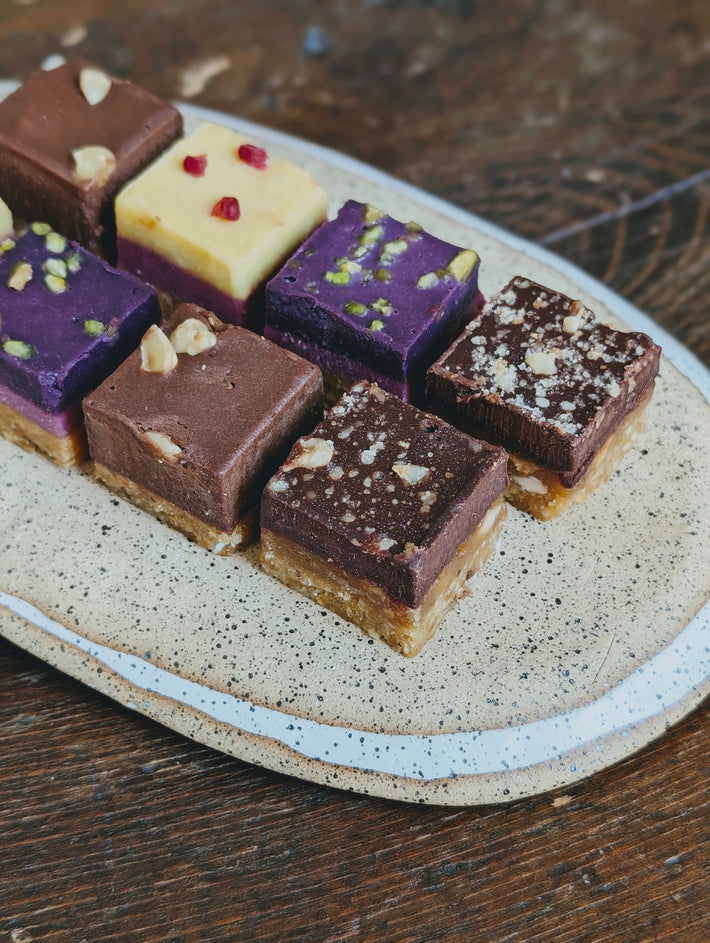 A plate of assorted layered desserts with various toppings