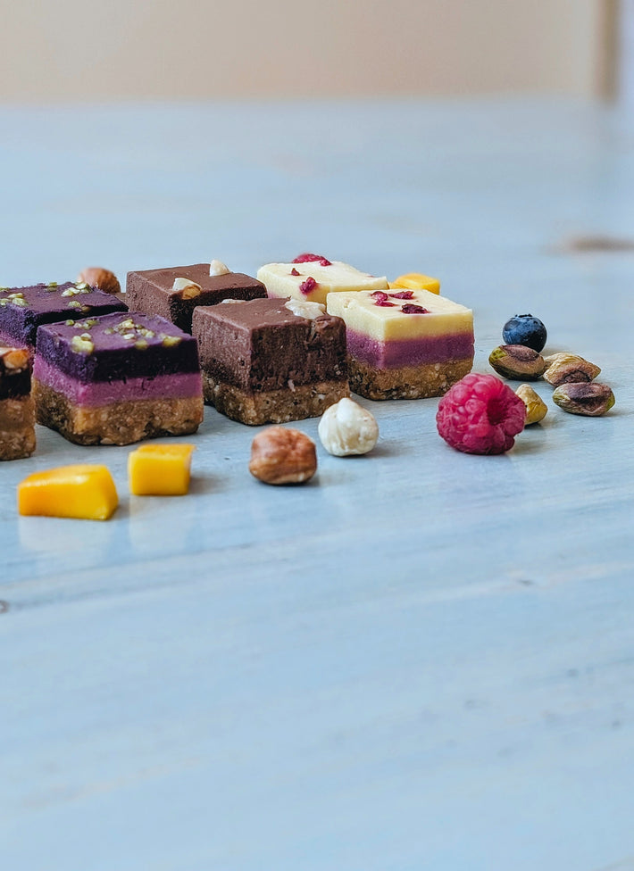 A variety of colorful layered desserts with nuts and fruits on a wooden table