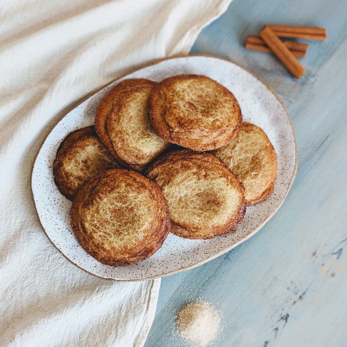 Giant Snickerdoodle Cookies on a plate with cinnamon sticks and sugar