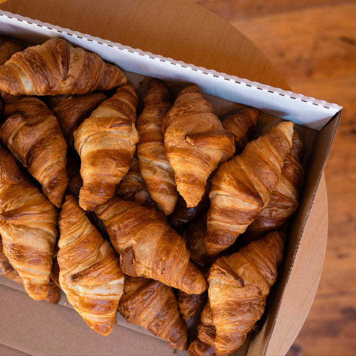 Box of croissants on a wooden surface