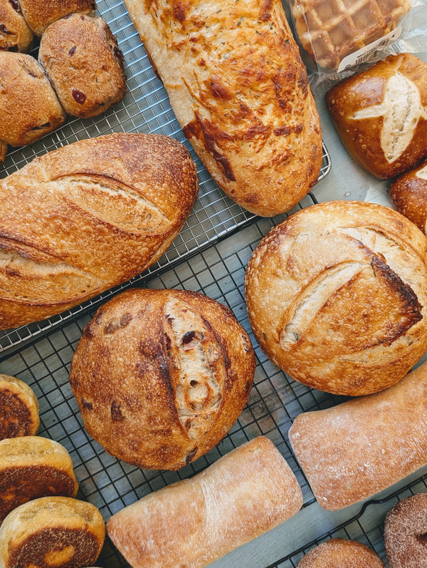 Assorted loaves of bread on a cooling rack