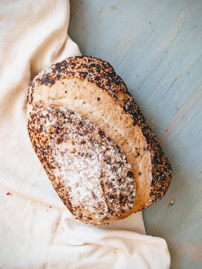 Loaf of bread with a crumbly texture on a light fabric background