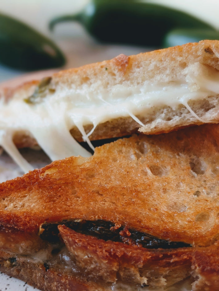 Close-up grilled cheese on toasted bread with melted cheese stretching between slices