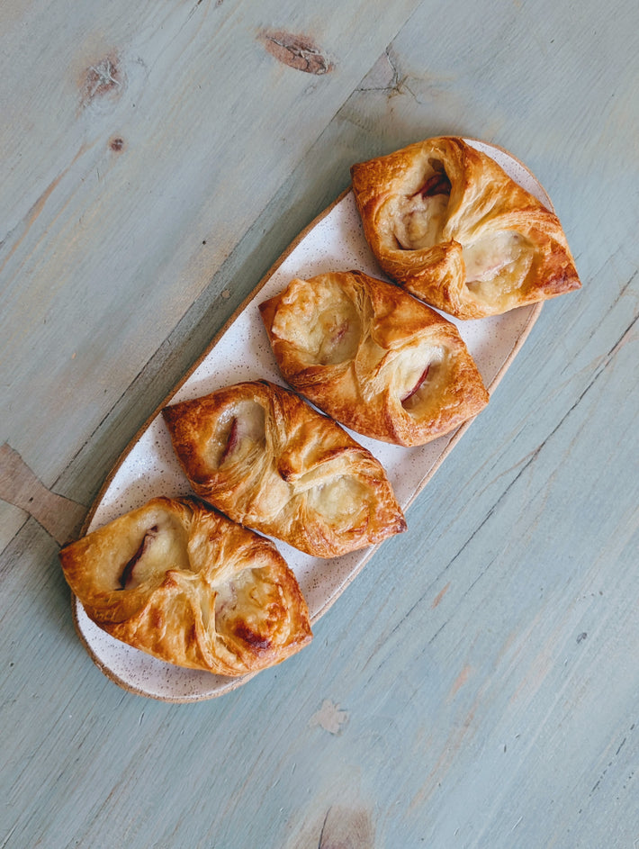 Four Ham & Cheese Croissants on a plate, golden-brown and flaky.