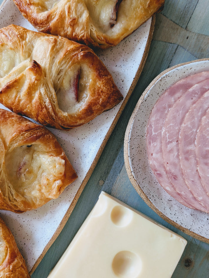Ham & Cheese Croissants on a plate with sliced ham and cheese.