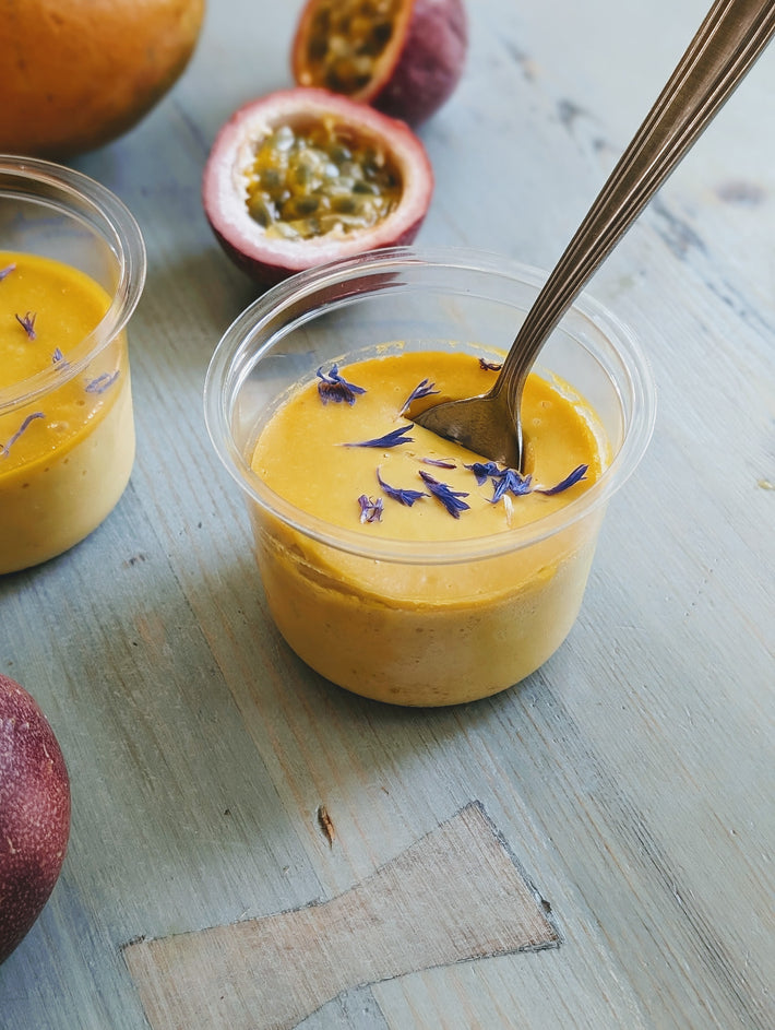 Mango & Passion Fruit Mousse topped with cornflower petals in a clear cup