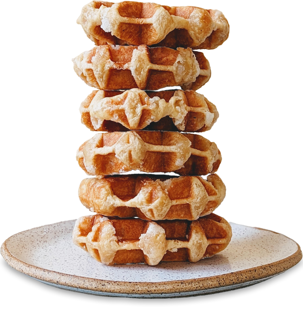 Stack of round golden Belgian waffles with sugar on a speckled ceramic plate
