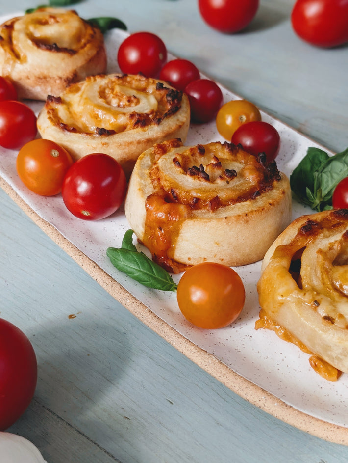Rolls with cheese and herbs on a plate with cherry tomatoes