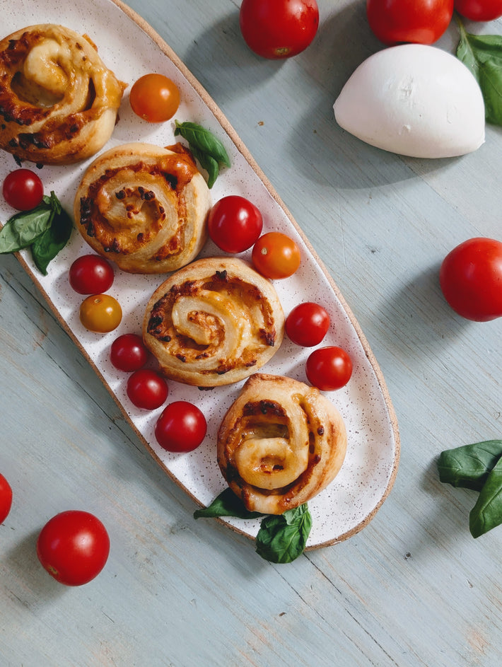Rolls with cherry tomatoes on a light blue surface