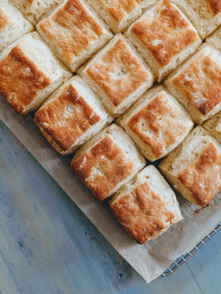 Square biscuits on a cooling rack with a blue wooden surface