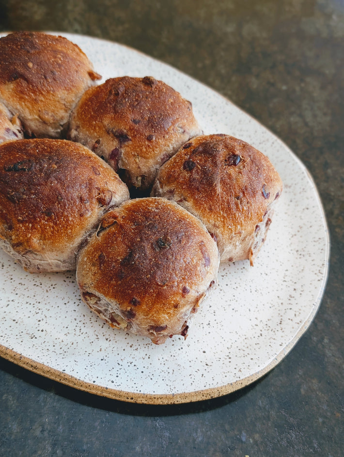 Tear & Share Cranberry-Pecan Rolls on a plate, showcasing their crispy tops and round shape.