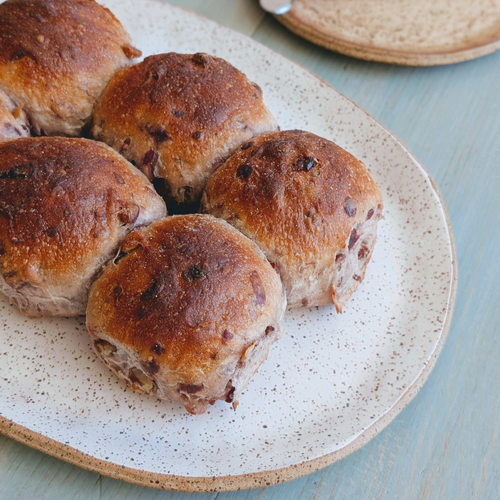 A plate of freshly baked cranberry-pecan rolls, arranged neatly.