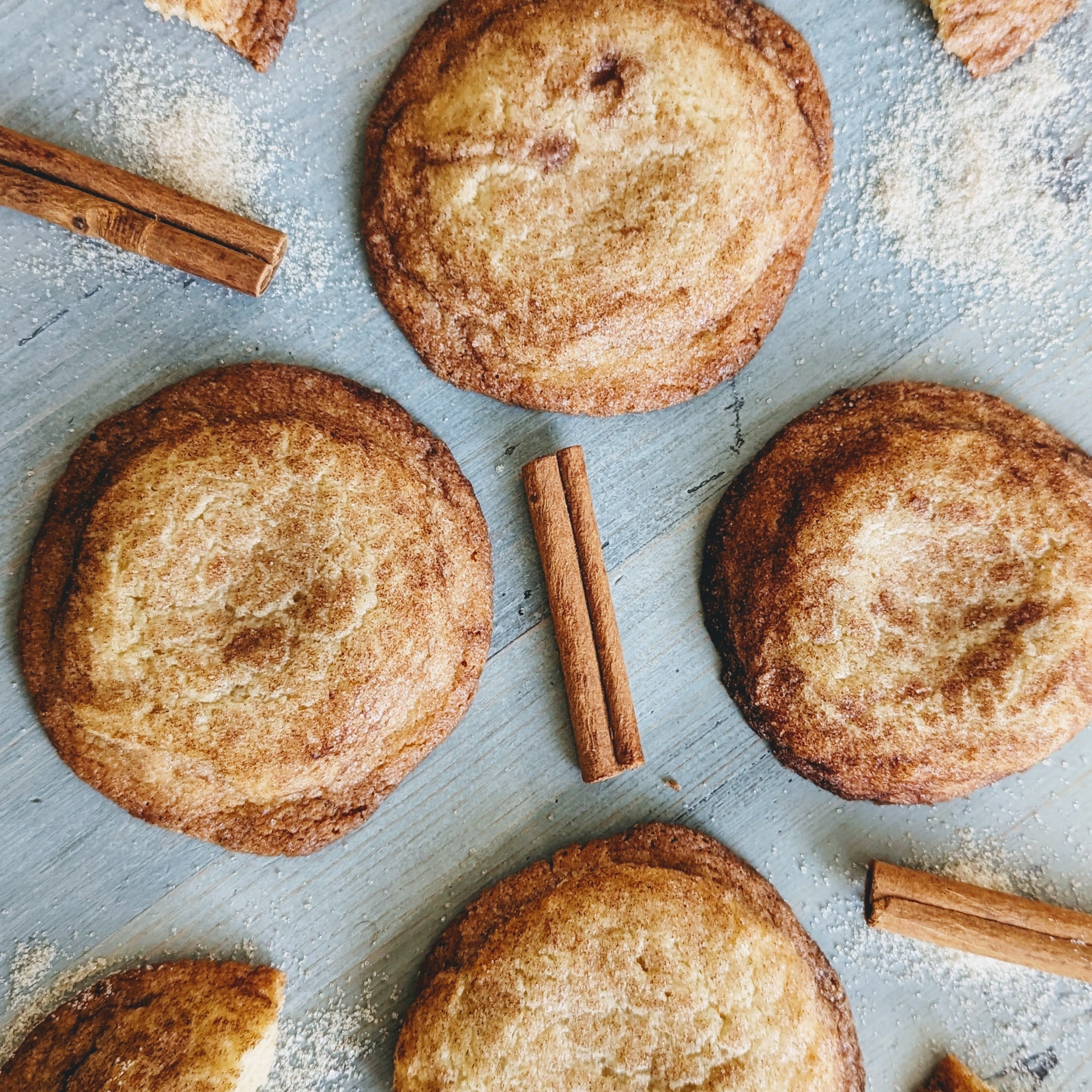 Close-up of gluten-free giant snickerdoodle cookies with cinnamon sticks on a wooden surface