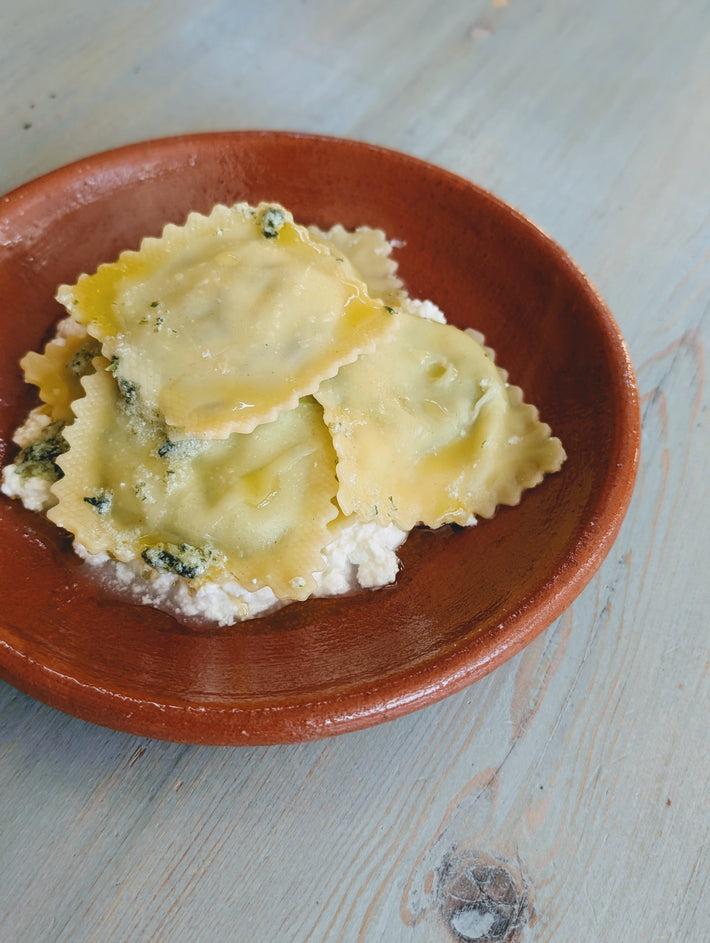 Spinach & Ricotta Ravioli served on creamy cheese