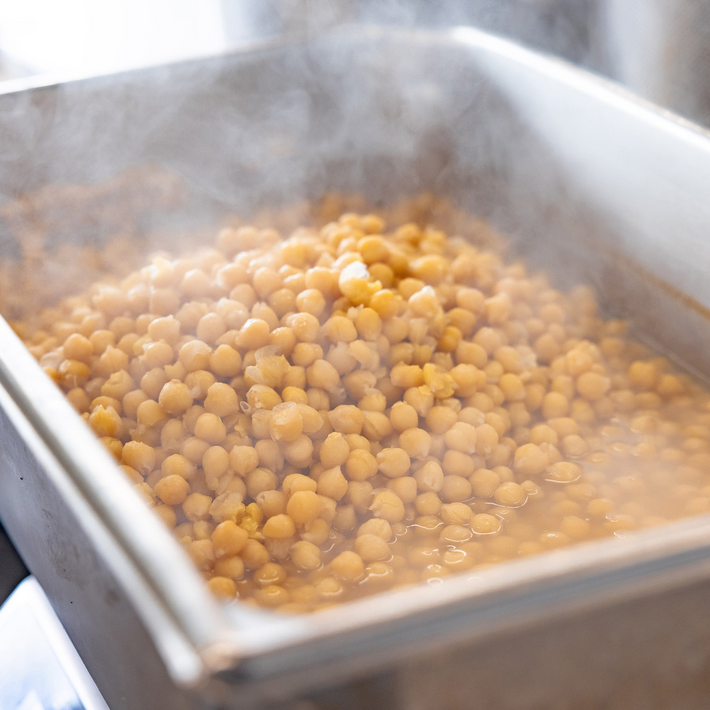 Boiling chickpeas in a metal pan on a stove