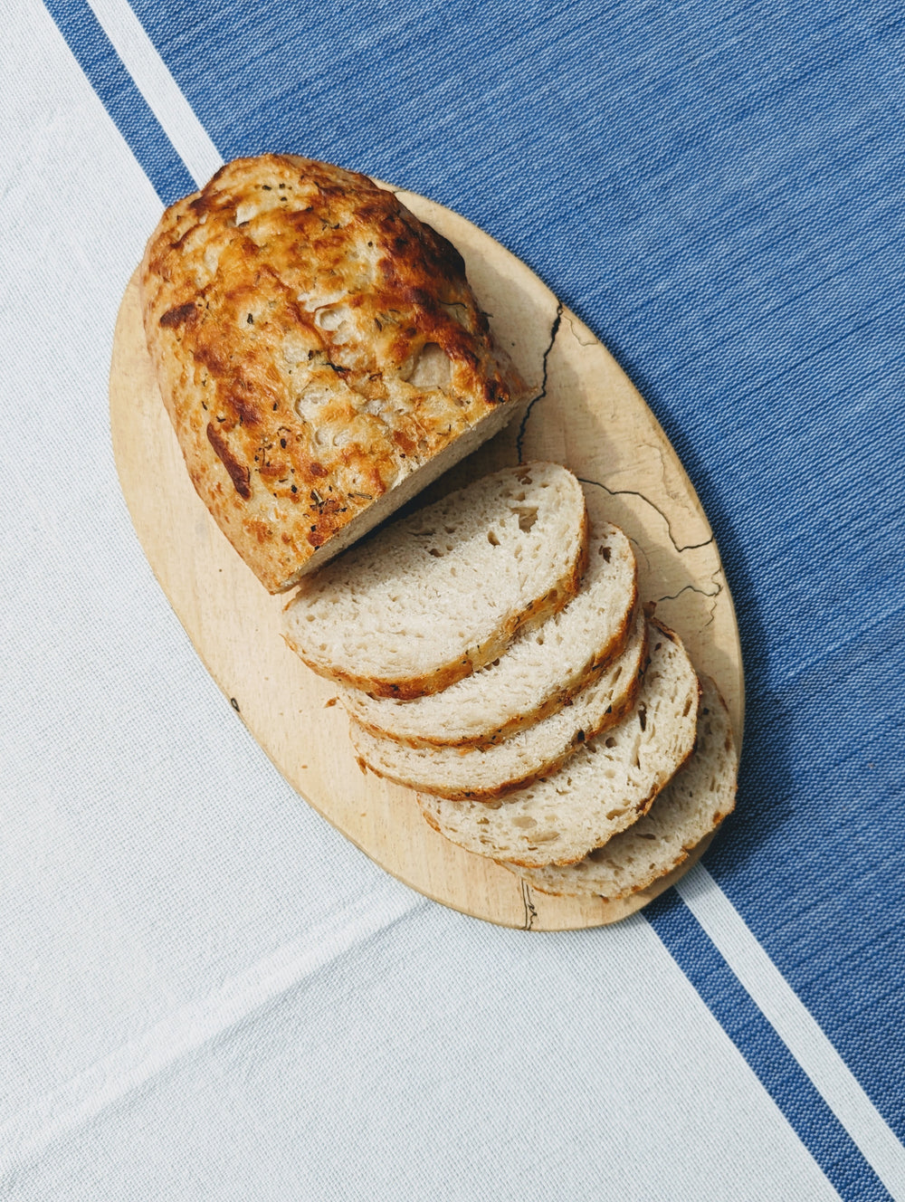 Sourdough 3-Cheese Loaf on a wooden board with sliced pieces