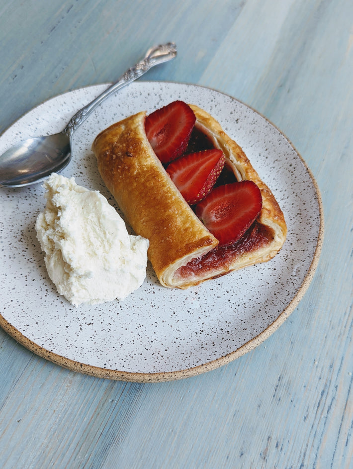 Strawberry Rhubarb Turnover with whipped cream on a plate
