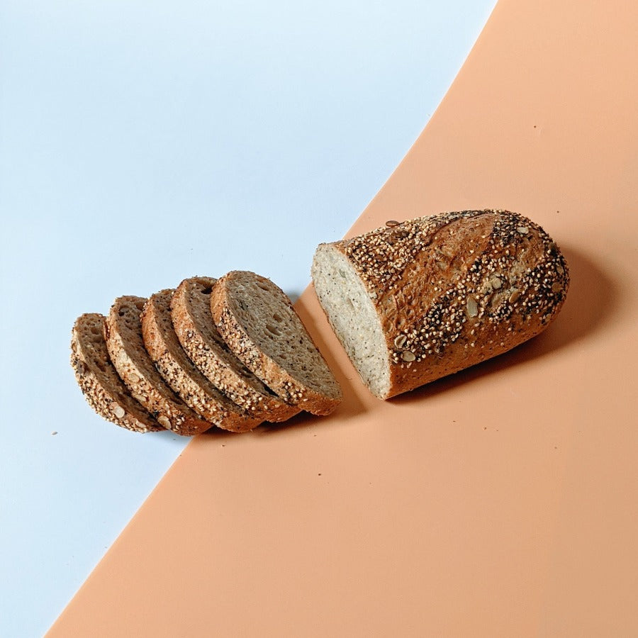 Sliced Wildgrain 3-seed bread on a colored background