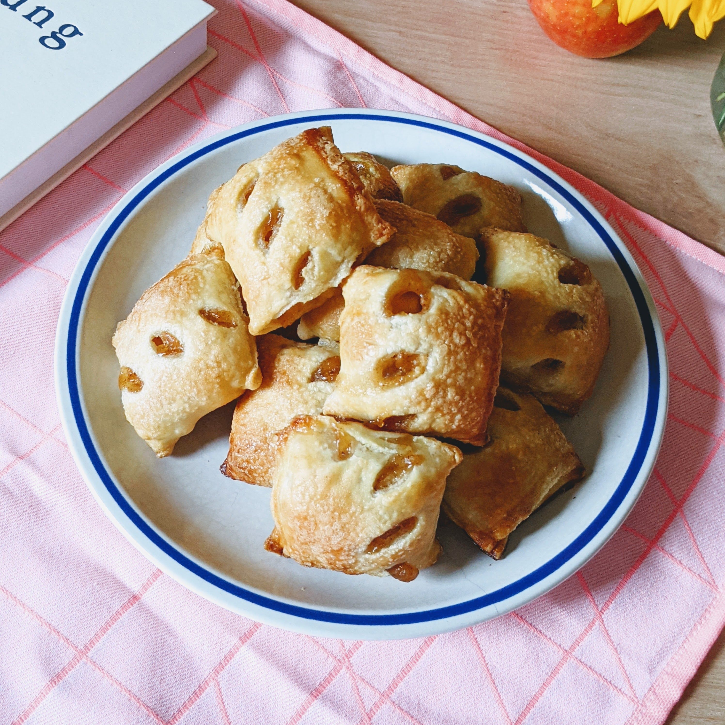 A plate of baked Wildgrain Apple Pie Bites, golden and flaky, with visible apple filling.