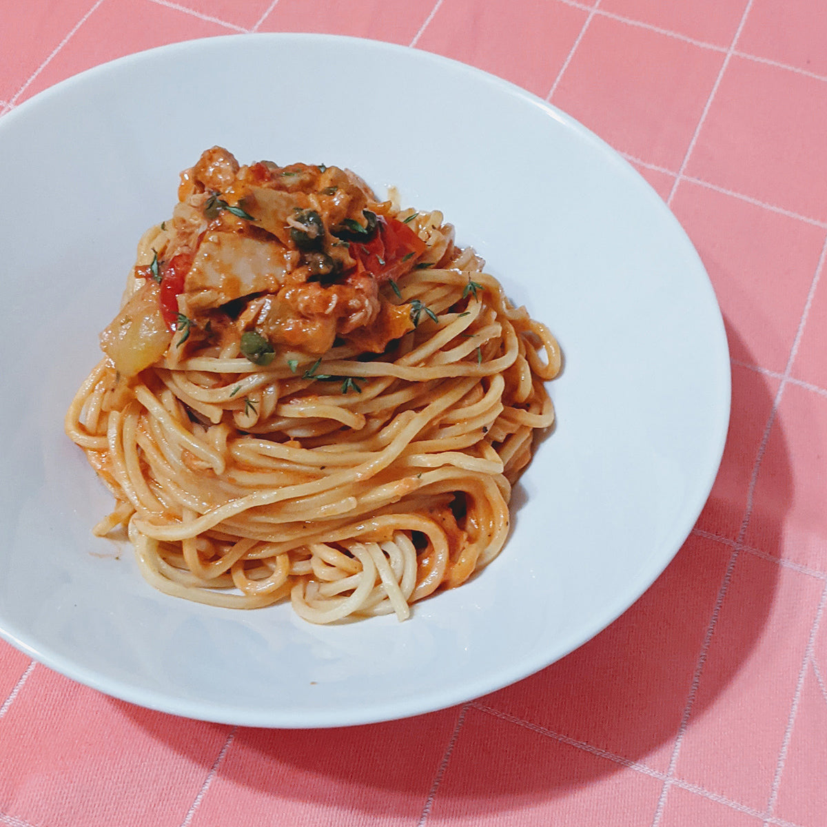 Plate of Fresh Tonnarelli pasta topped with sauce and herbs