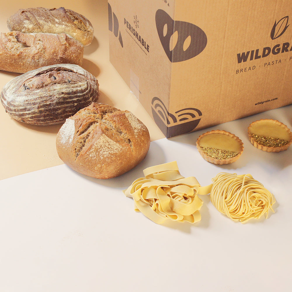 Assorted breads and pasta next to a Wildgrain box